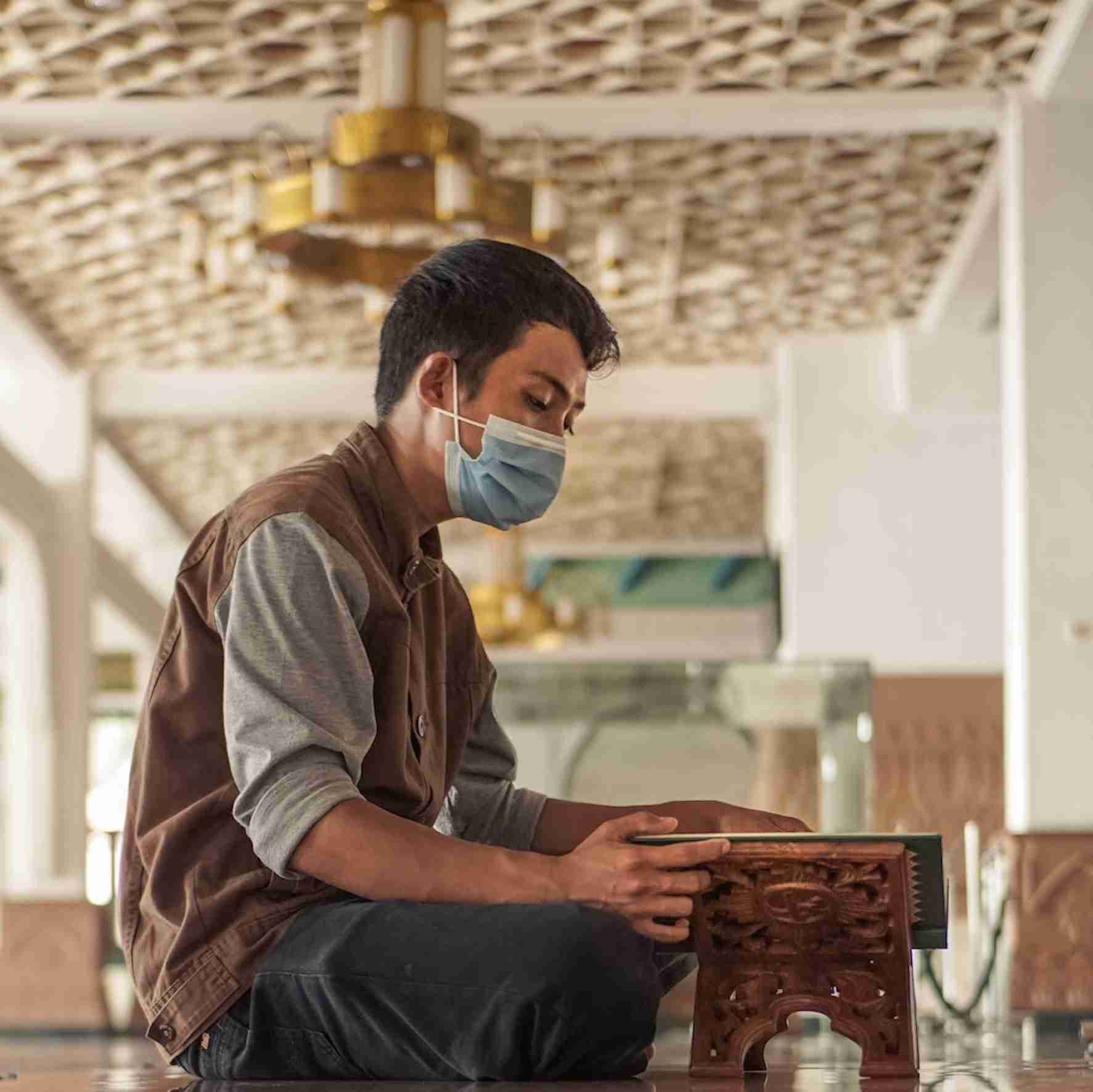Masked man praying during Ramadan